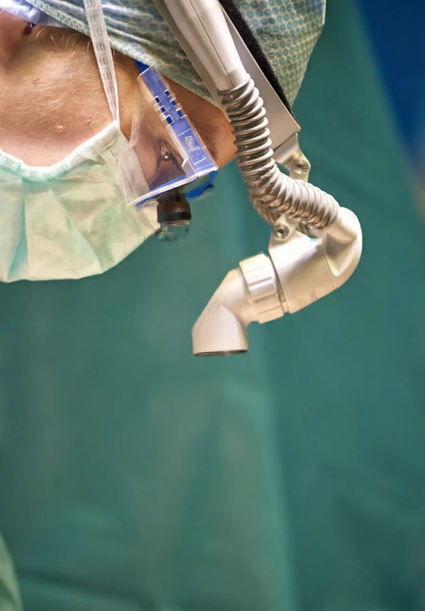 Close up of a surgeon operating on a disc replacement surgery, showing the surgeon's head looking down